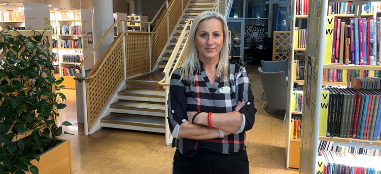 Foto på Kremena Söderström, rektor på Igelsta grundskola, när hon står i biblioteket.