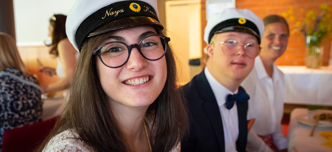 Närbild på en tjej med studentmössa. En kille i studentmössa syns bakom.