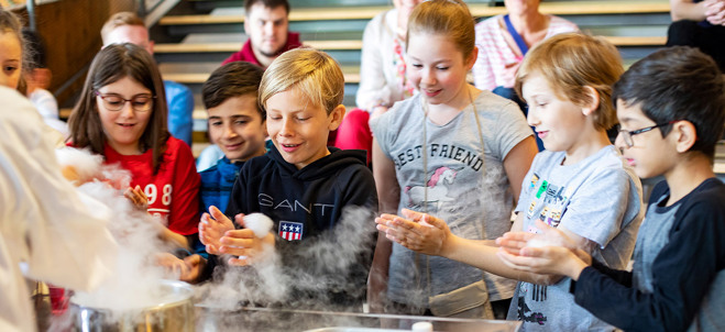 Fotografi på barn som deltar i ett experiment på Tom Tits i Södertälje.