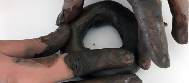 Bild på ett par händer som formar lera
