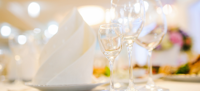 Dukat bord med tomma vinglas i förgrunden.