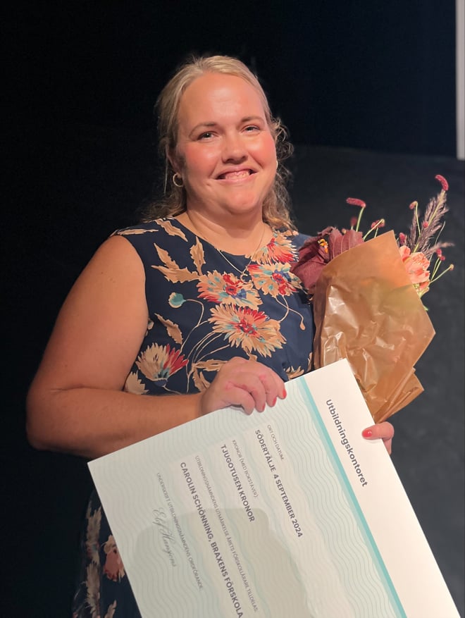 Carolin Schönning håller upp diplom för årets förskolelärare 