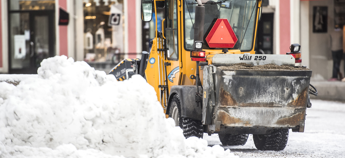 Snöplog plogar snötäckt väg