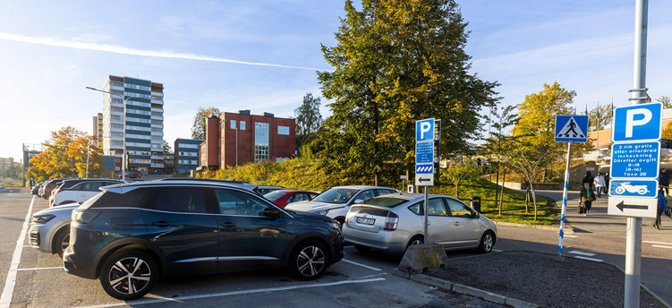 Parkeringsplats med bilar och en skylt med 2 timmar avgiftsfri parkering