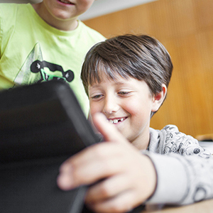 Bild på barn i skolmiljö med en dator.