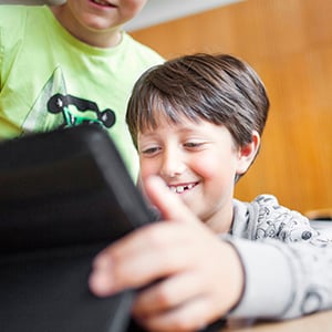 Bild på barn i skolmiljö med en dator.