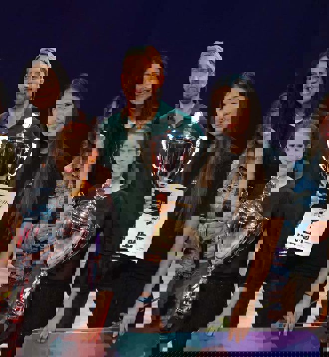 Ungdomar får prispokaler vid en prisceremoni.