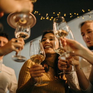 Bild på ett gäng människor som skålar med varandra.