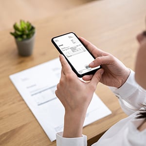 Person som betalar sin faktura i mobilbanken