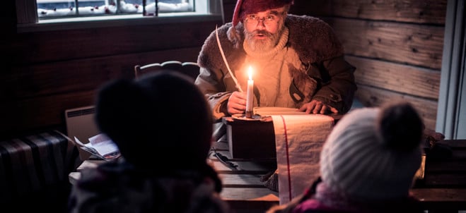 Två barn sitter vid ett bord framför tomten