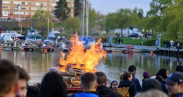 majbrasa på vattnet med folksamling och båtar