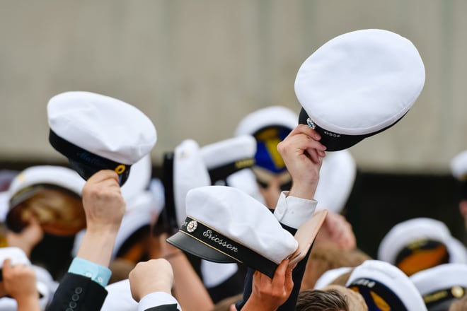 Studenter som firar med studentmössor i luften