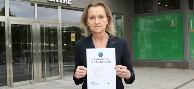 Boel Godner (S), kommunstyrelsens ordförande står utanför stadshuset i Södertälje med deklaration för en stark demokrati, som hon signerat.