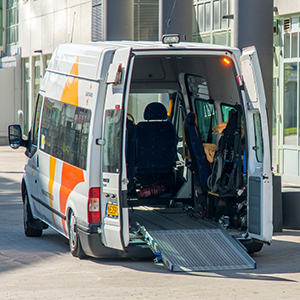 En färdtjänsttaxi med rampen utfälld.