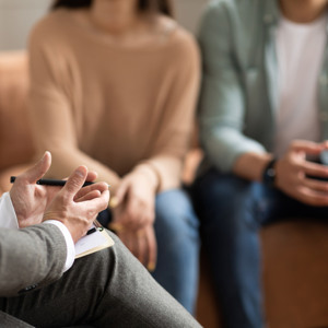 Bild på ett par som sitter i en soffa och pratar med en behandlare.