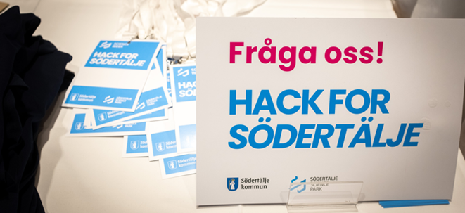 Skylt med text: Fråga oss! Hack for Södertälje.