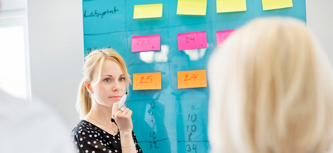 Kvinna vid whiteboard med post it-lappar